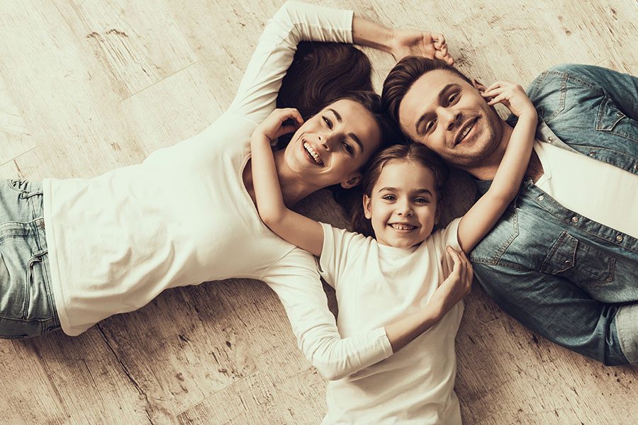 Personal Insurance - Happy Family with Daughter Laying on Floor At Home